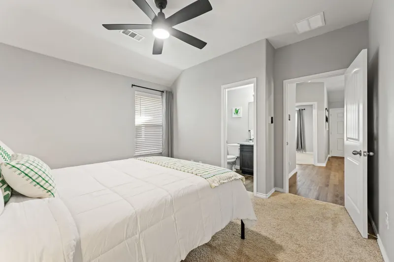 Primary bedroom with crisp white bedding and an en-suite bath
