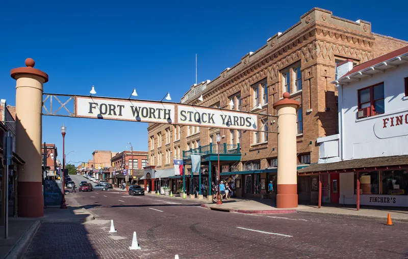 The Fort Worth Stock Yards entrance sign over Exchange Avenue under a blue sky