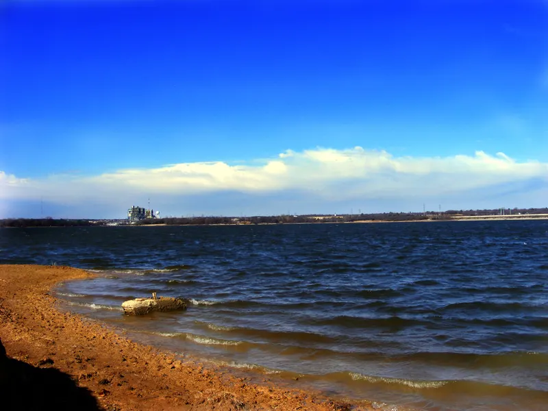 Waves rolling onto the shore of Lake Arlington under a blue sky